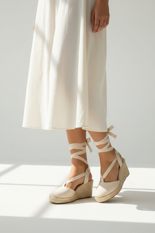 Model wearing beige lace-up espadrille wedges front view
